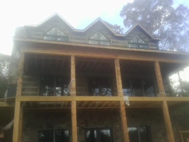 Dormers and porch framing on a large log home under construction — Roof Coating work by our crew in Diablo
